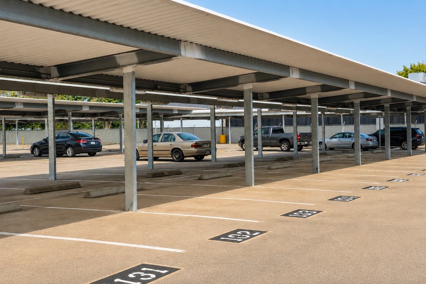 Covered parking under steel canopies at Hobby Airport Parking, shielding vehicles left for long-term stays from Houston sun and rain