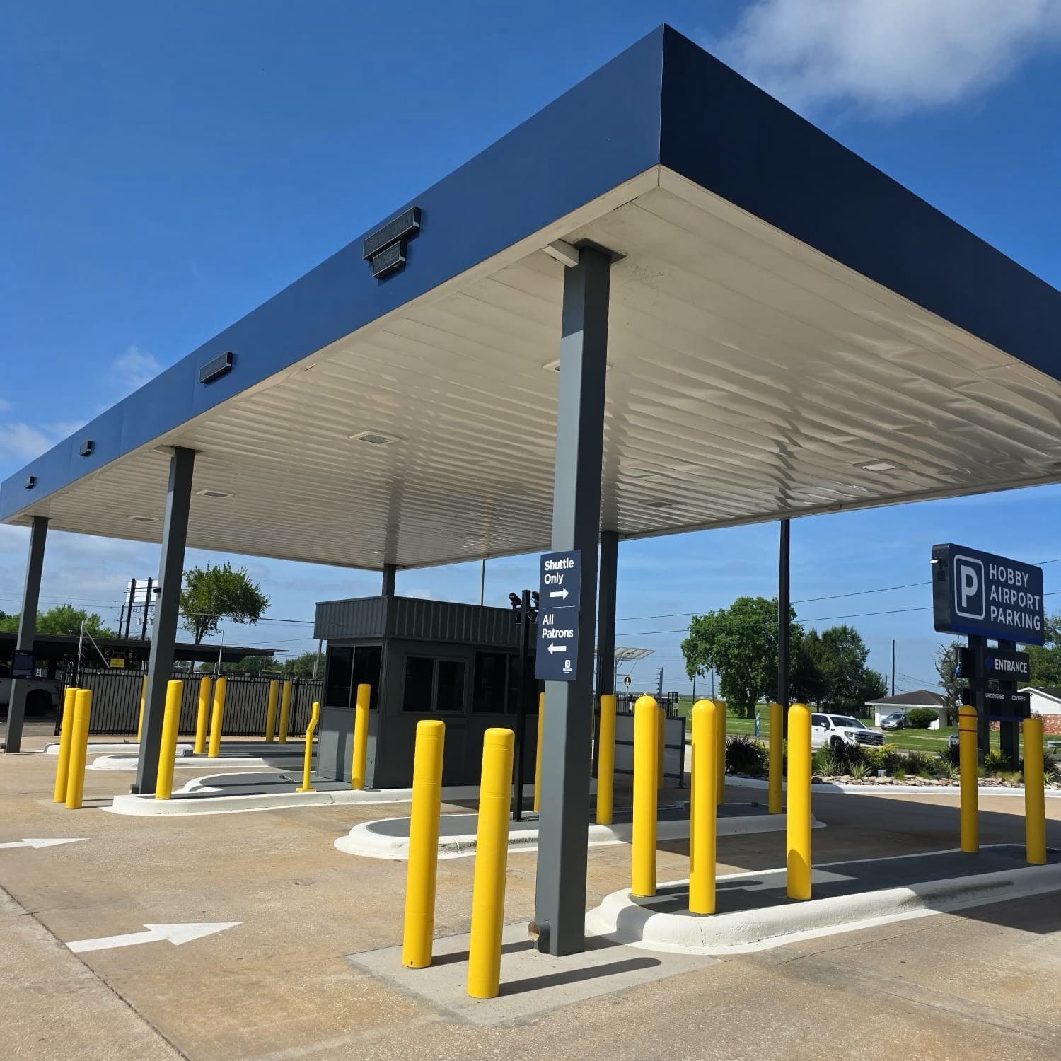 Entry canopy and staffed booth at Hobby Airport Parking, with the illuminated monument sign at the gate